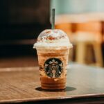 white and brown starbucks coffee cup on brown wooden table